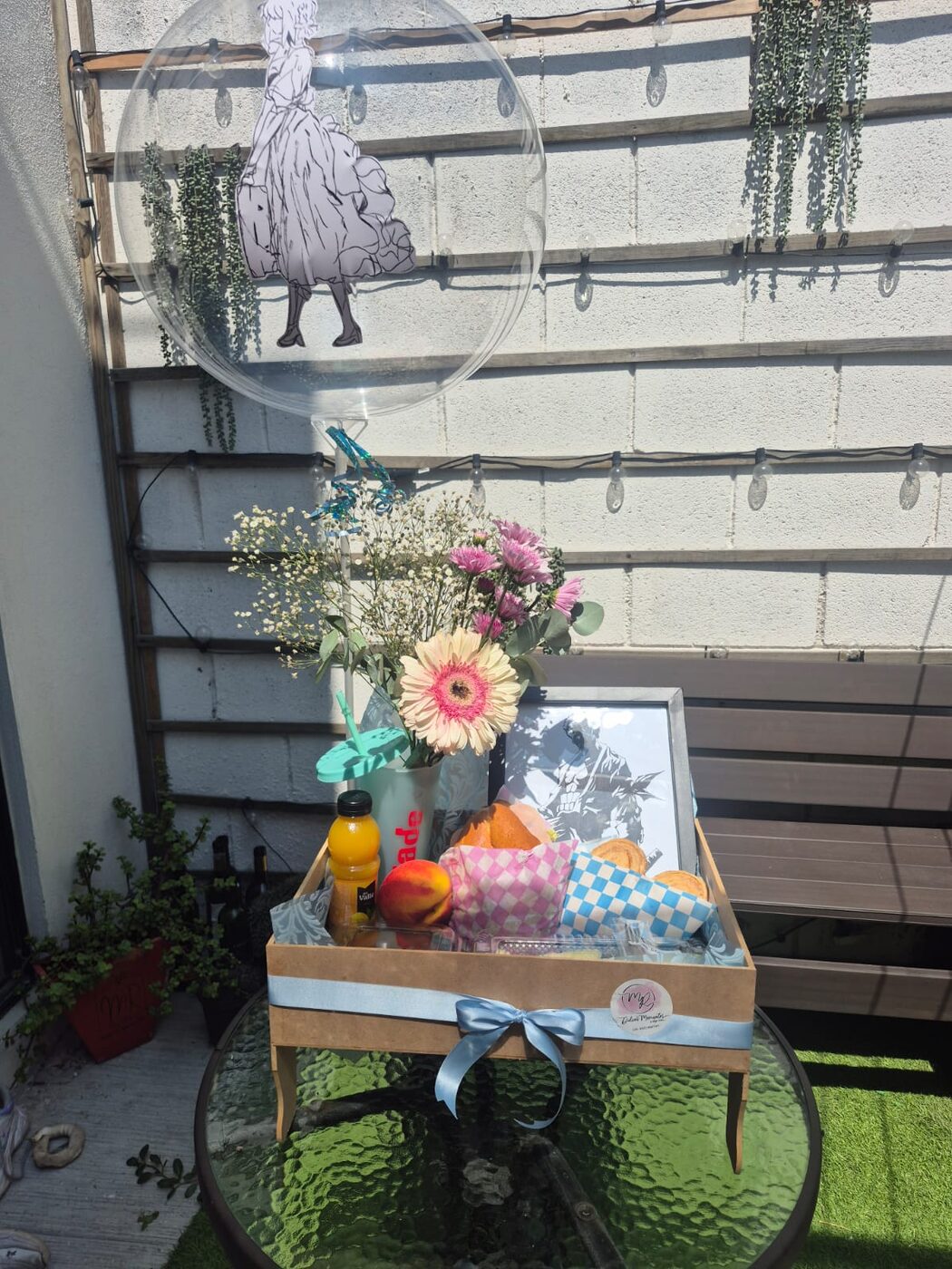 Desayuno sorpresa con flores, jugo, fruta y pan en charola de madera