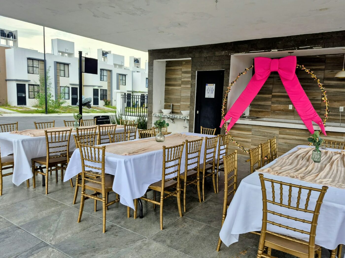 Mesas con manteles blancos y sillas doradas montadas para un evento